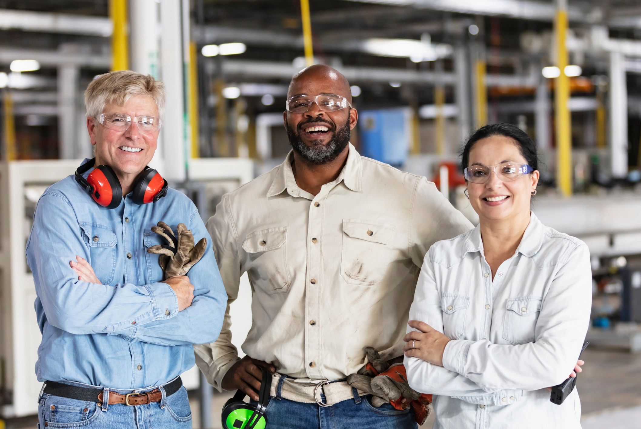 Three workers standing together in an industrial setting
