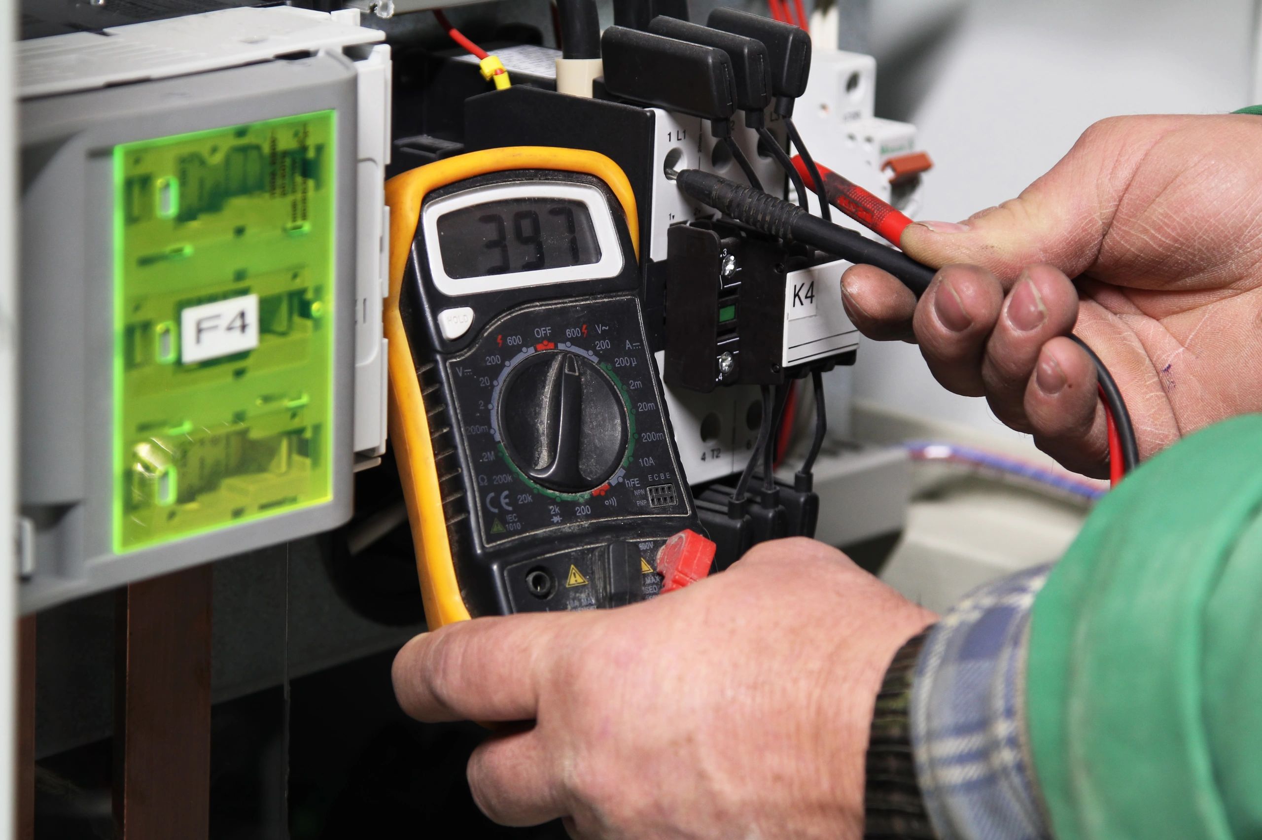 Electrician testing an electrical panel with a digital multimeter